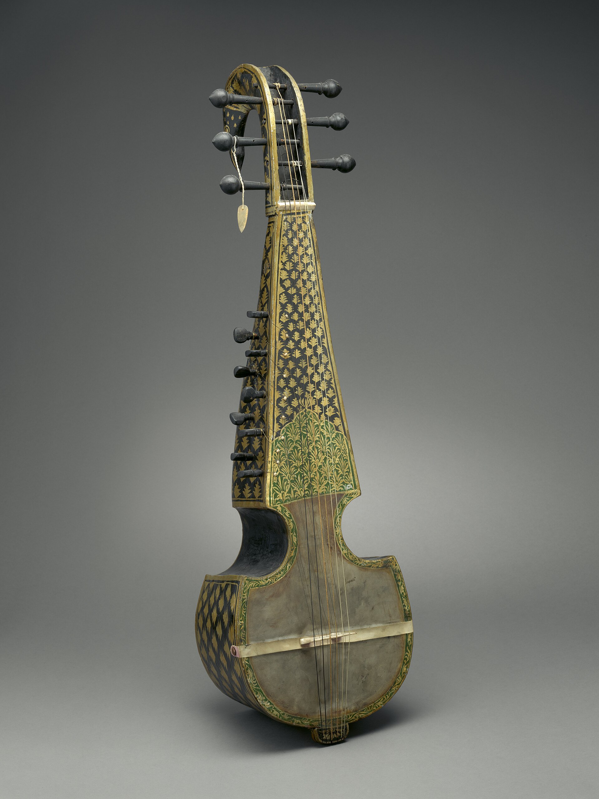 Museum photograph of a sarod resting against a plain ground